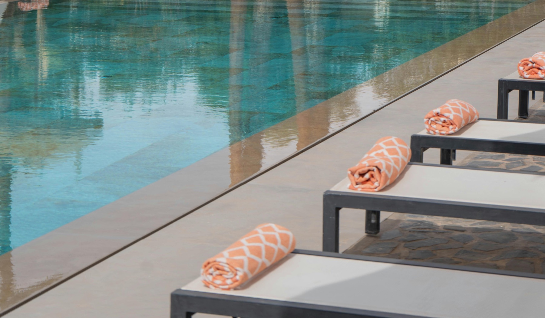 Transats et serviettes au bord d'une piscine — moment de détente en villa