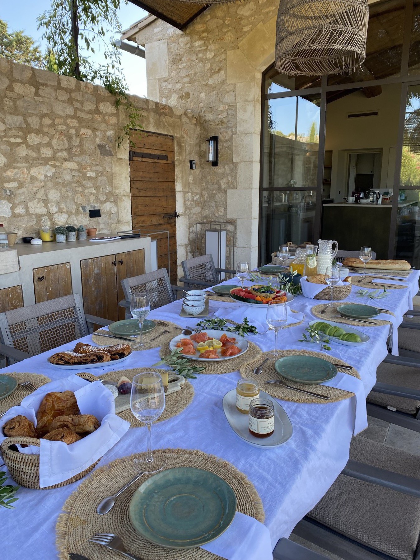 Grande table de petit-déjeuner extérieure dressée avec soin en Provence